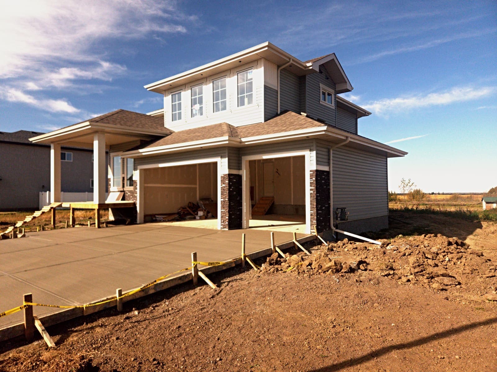 Three-quarter view of the Olivia showing the covered veranda on square white columns and the new concrete driveway