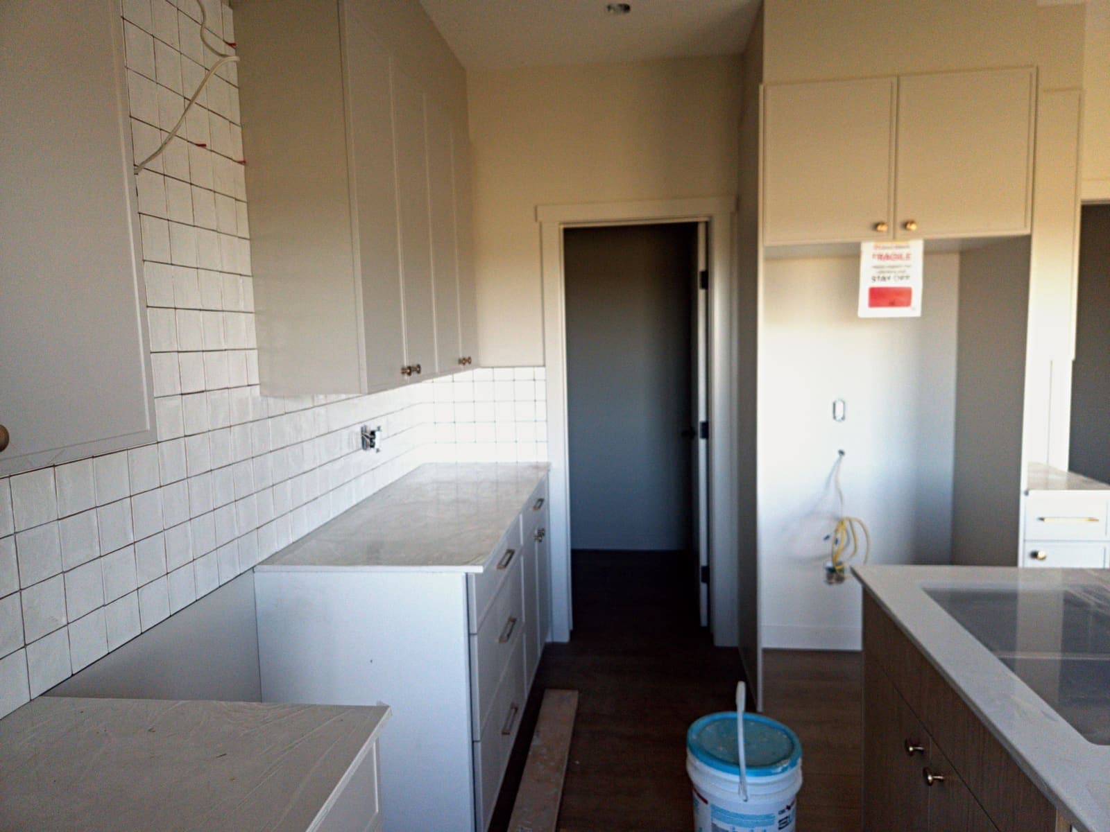 Kitchen backsplash and tall cabinets beside the pantry door