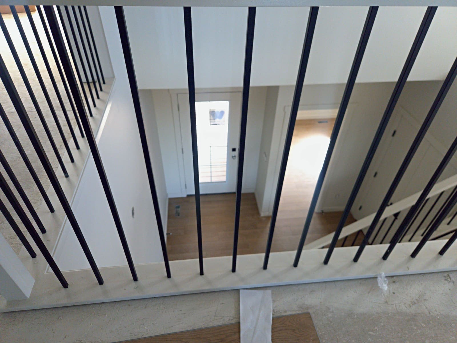Looking down through the black square balusters to the front entry