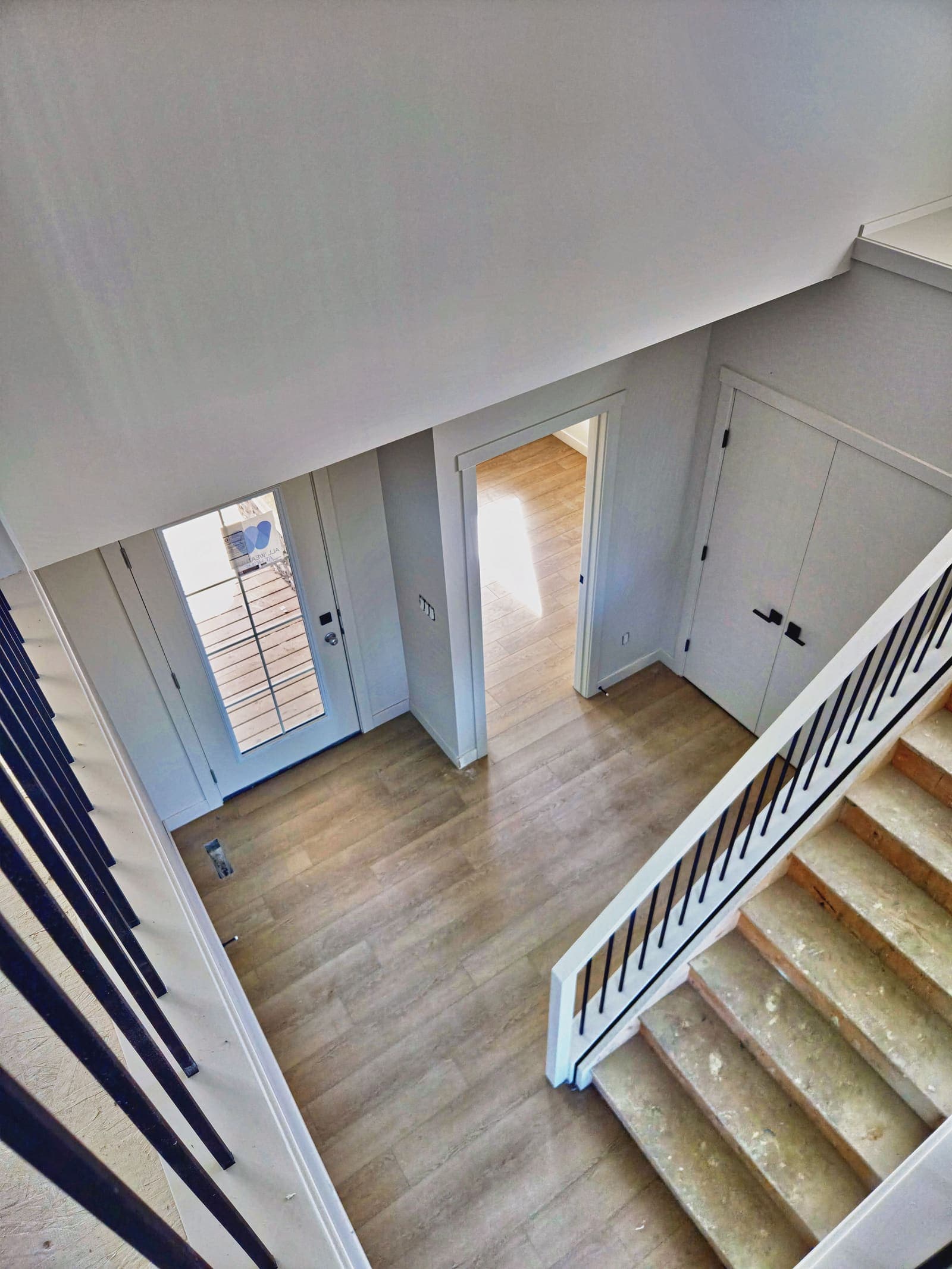 Front entry seen from the stairs, with white slab doors and matte black lever handles